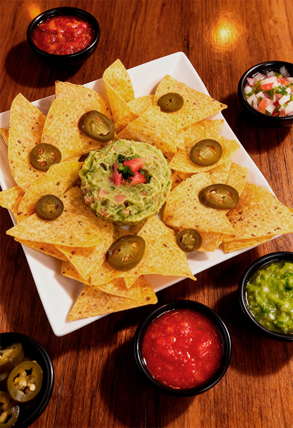 Nachos con guacamole en Takeria Olmeka, totopos crujientes con guacamole fresco y toppings típicos mejicanos.