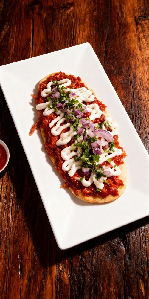 Huarache de pollo con mole en Takeria Olmeka, plato tradicional mejicano con masa artesanal y salsa de mole.
